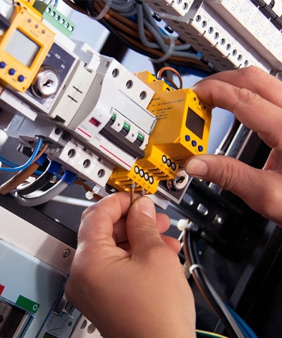 Technician measuring voltage on an electrical panel outdoors