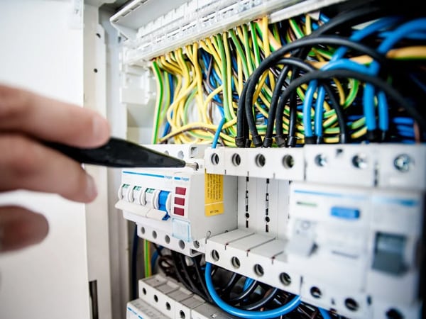 Electrician fixing an opened switchboard